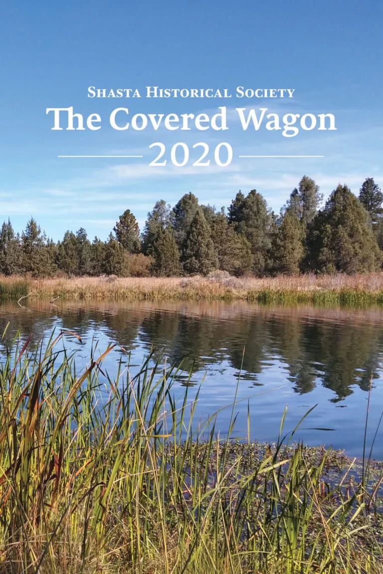 The Covered Wagon 2020" publication cover featuring a lakeside landscape with evergreen trees and marsh grasses.
